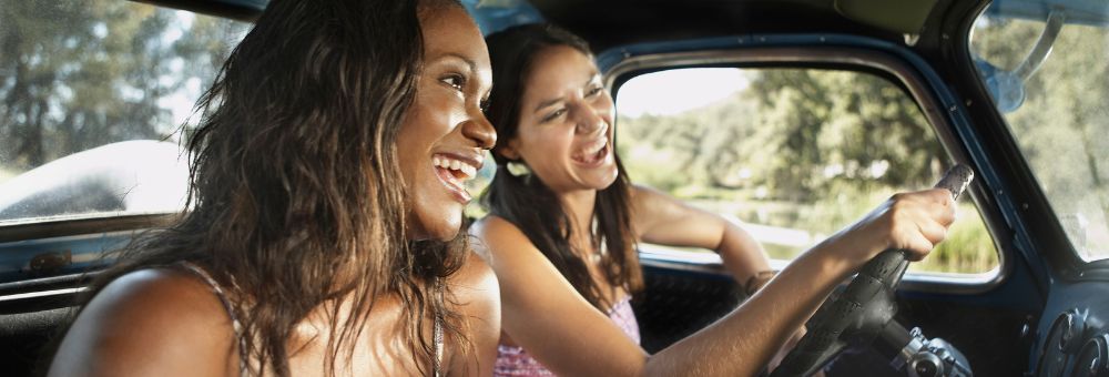 women driving and laughing